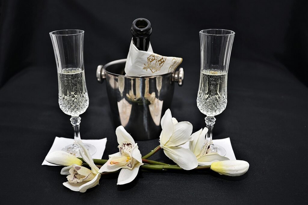 Two sparkling wine flutes, with a bottle of sparkling wine in an ice bucket